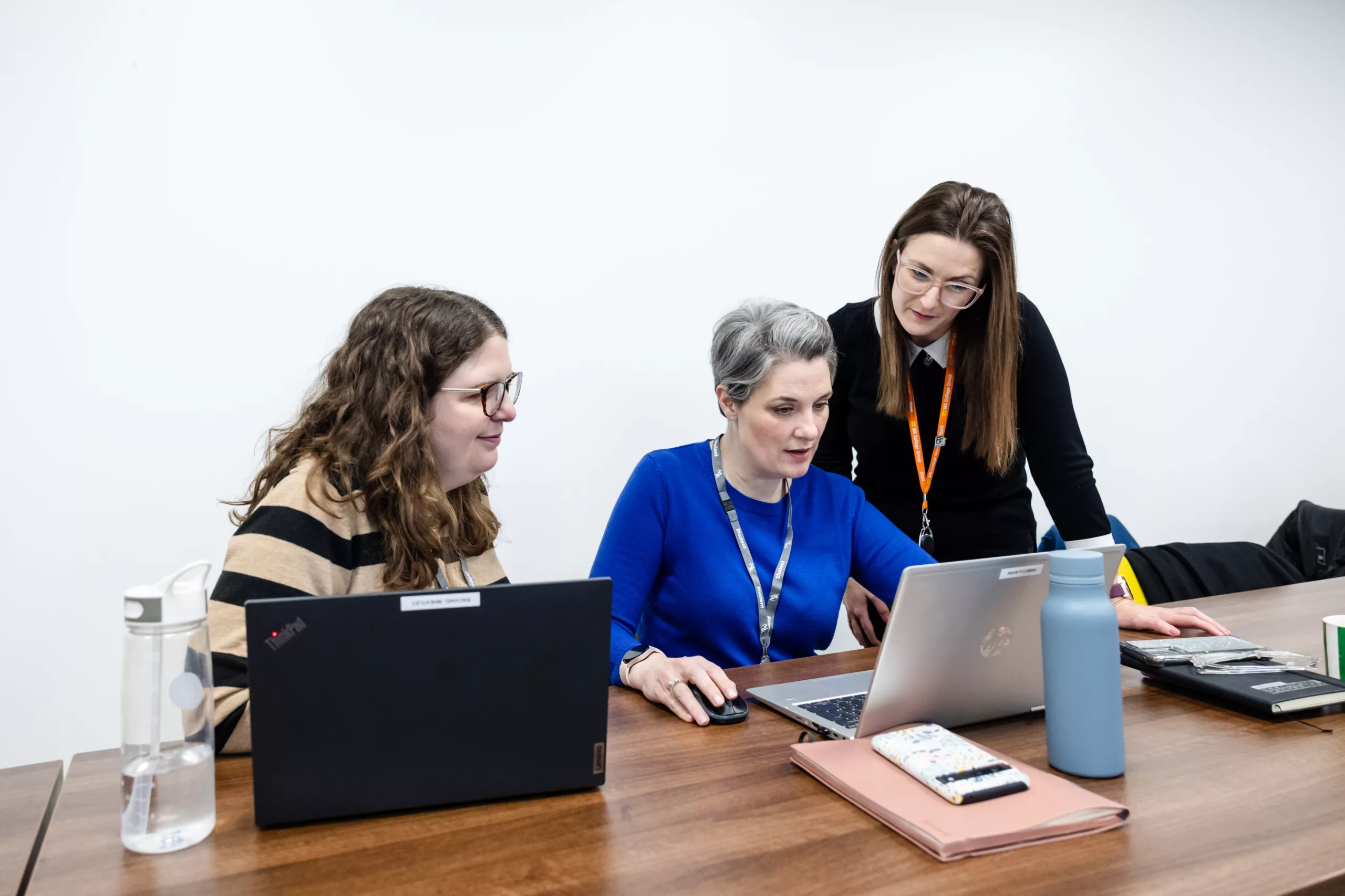 A group of students collaborating on a project using laptops, appearing engaged in discussion.