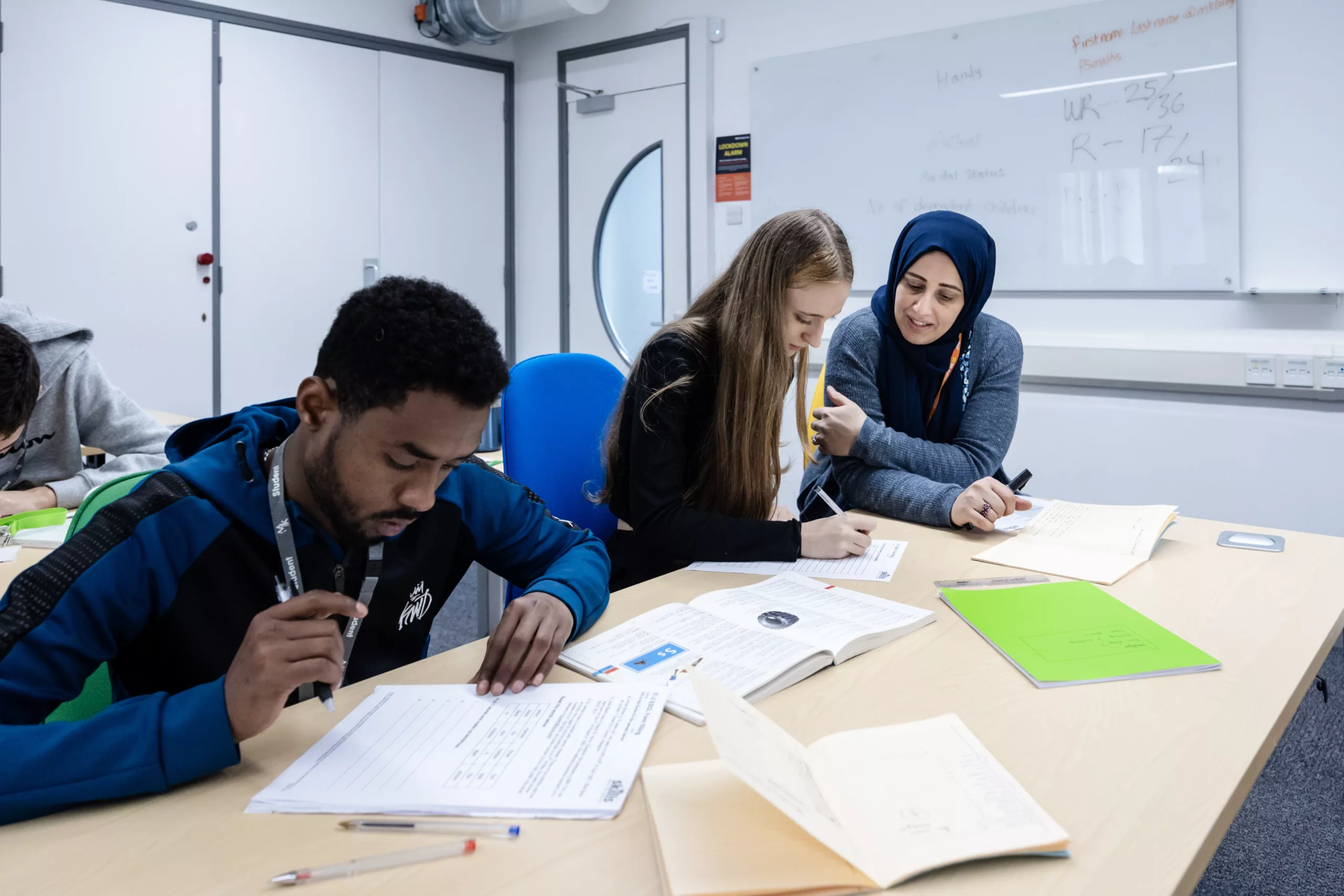 A group of students studying and taking notes in a classroom.