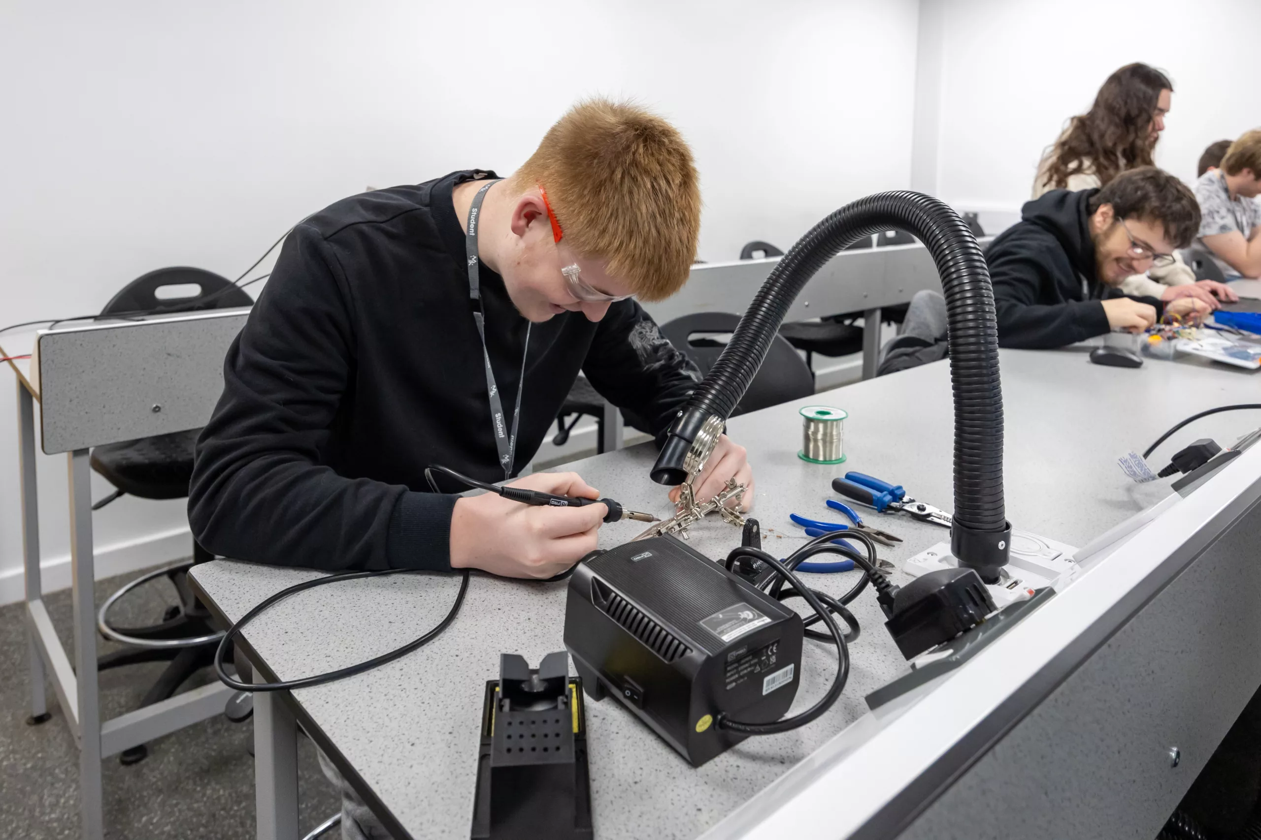 A student working with a robotic arm in an engineering lab.
