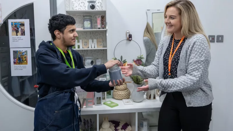 A lecturer assisting a student with a hands-on project.