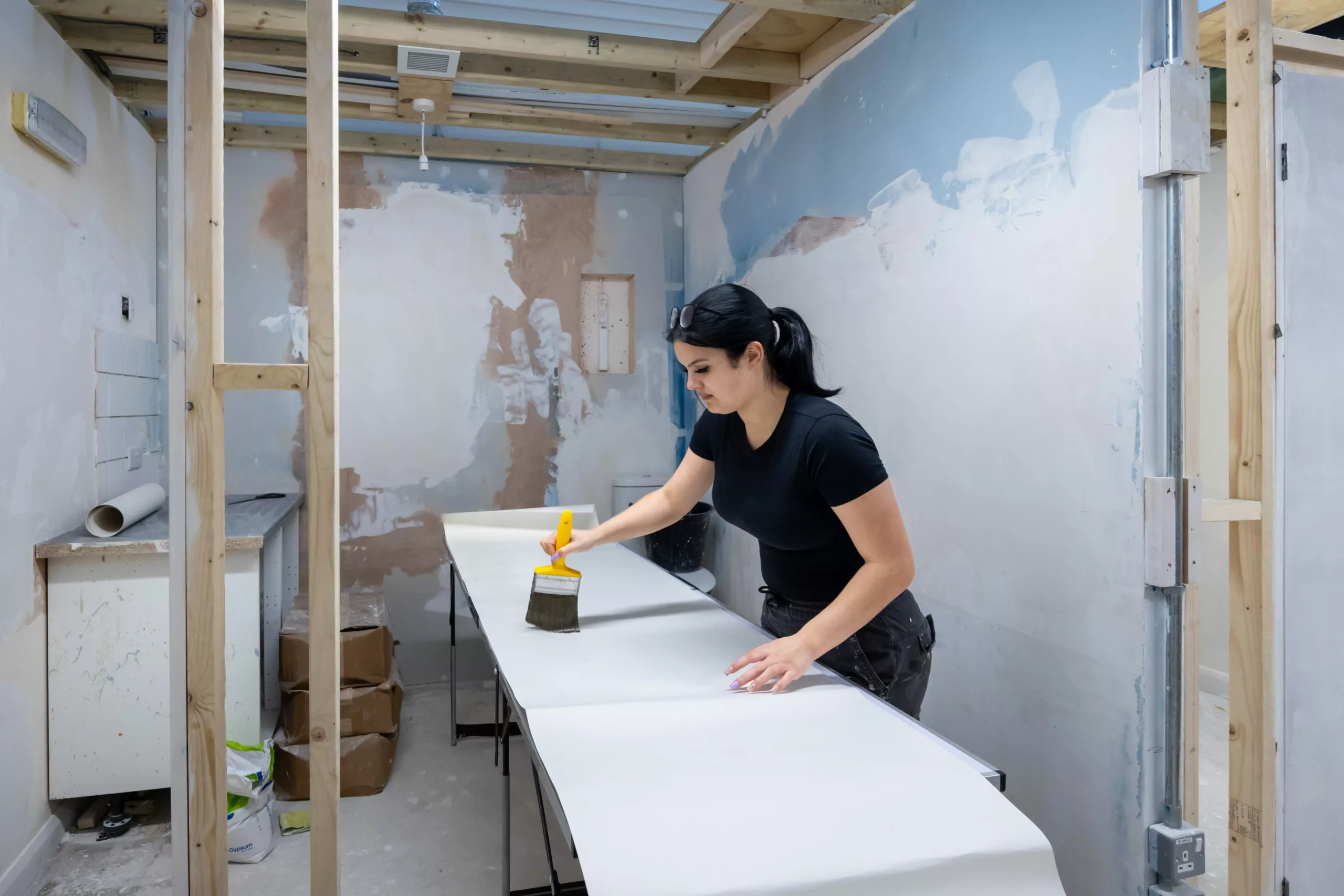 Painting and decorating student preparing wallpaper