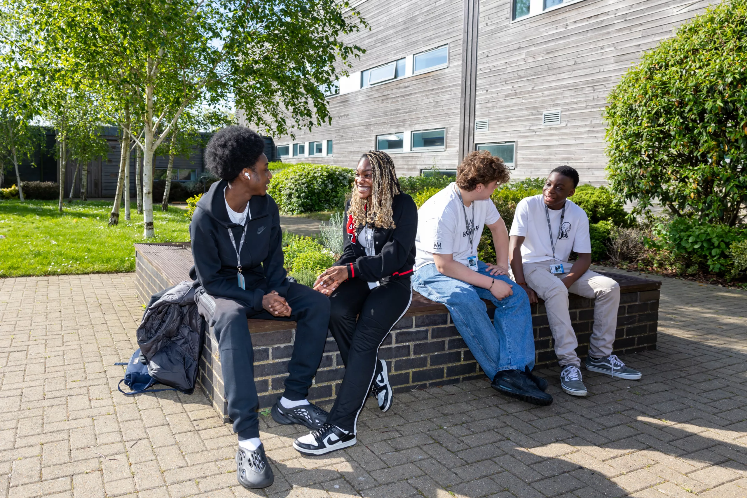 Students sitting outside, socializing on a sunny day.