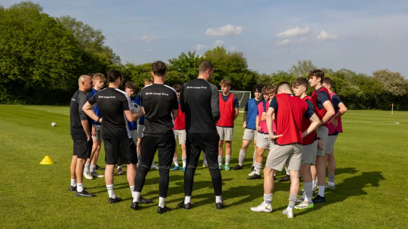 A football team standing outside on the grass