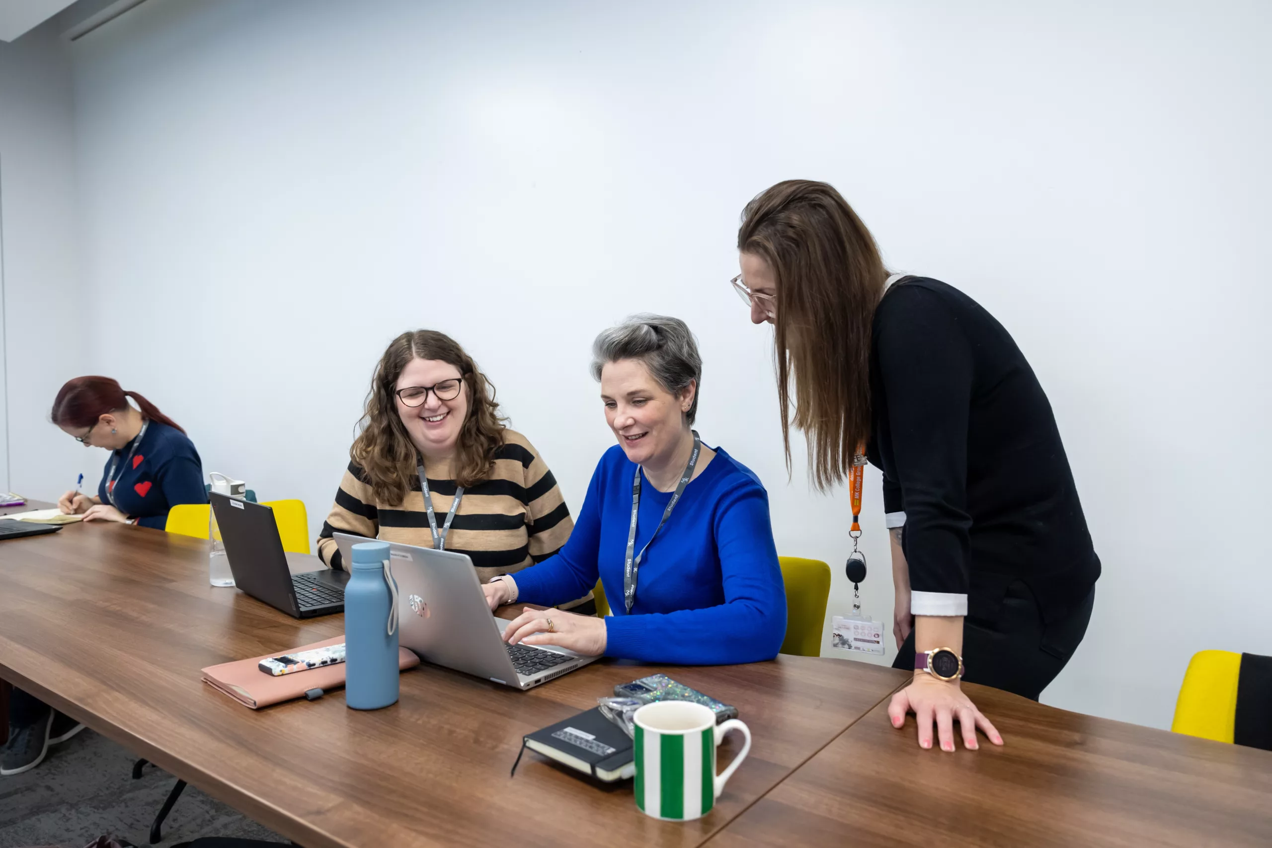 Adult learners working together on a laptoo