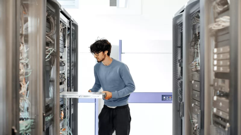 A man monitoring and maintaining a data server system.